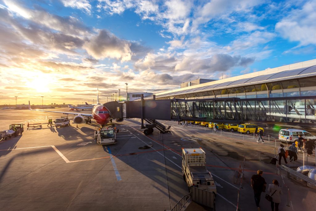 Airplaine at airport with groundservices and sunshine in the background